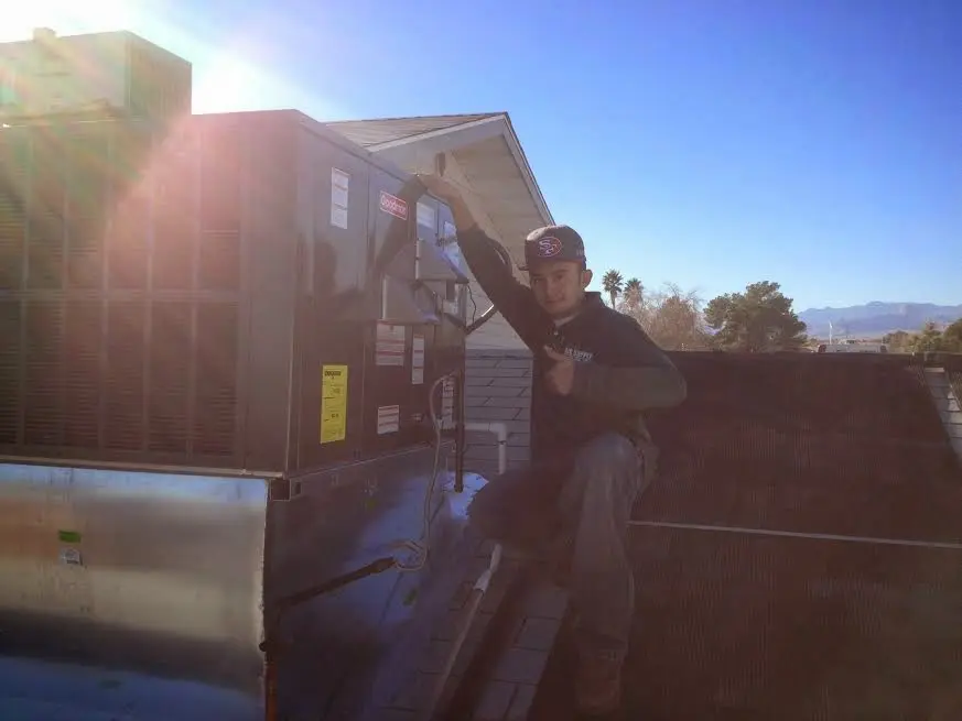 HVAC technician performing Heat Pump Repair on a rooftop unit in Belle Haven